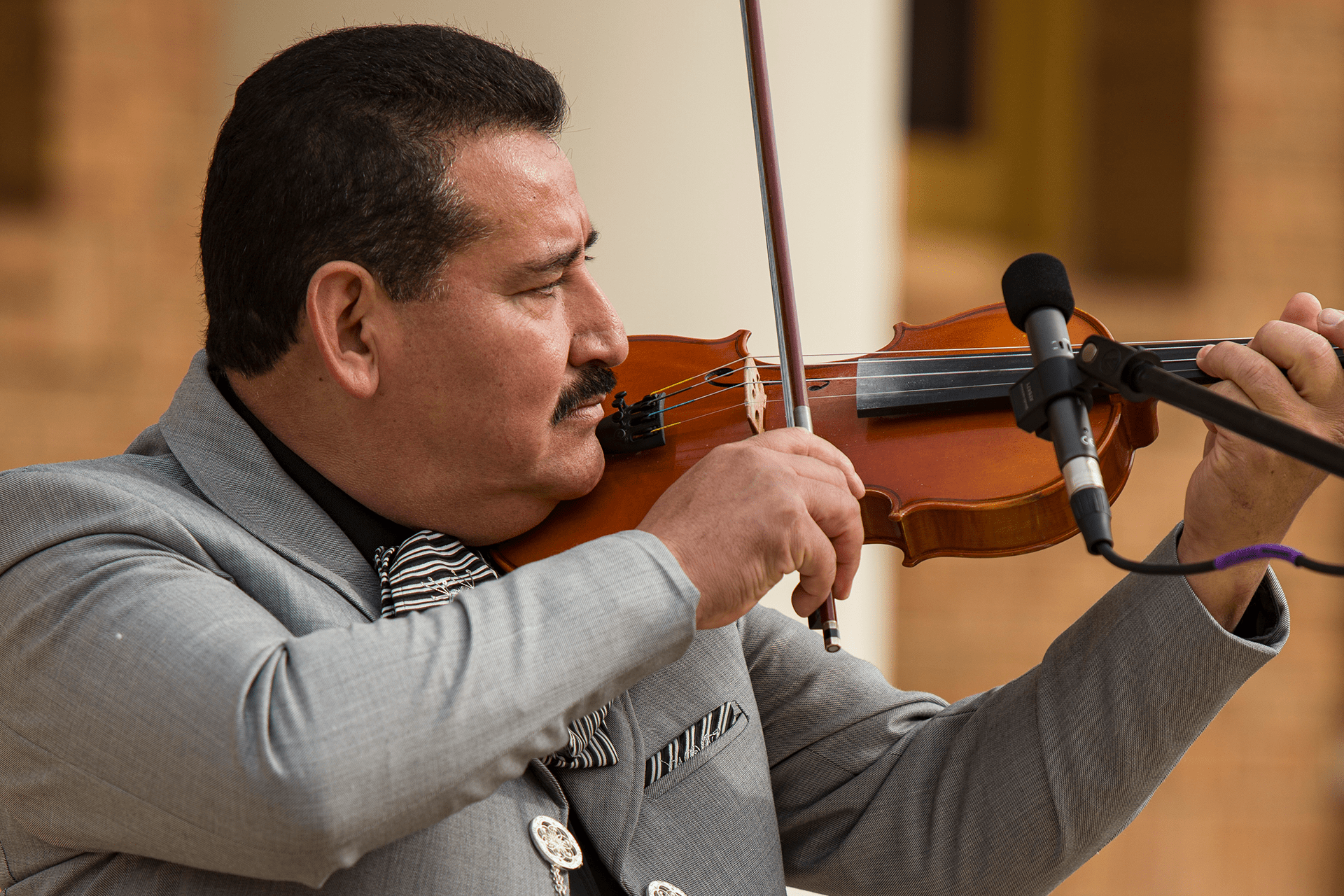Image of Mariachi Voces Tapatias musician playing the violin in front of City Hall.